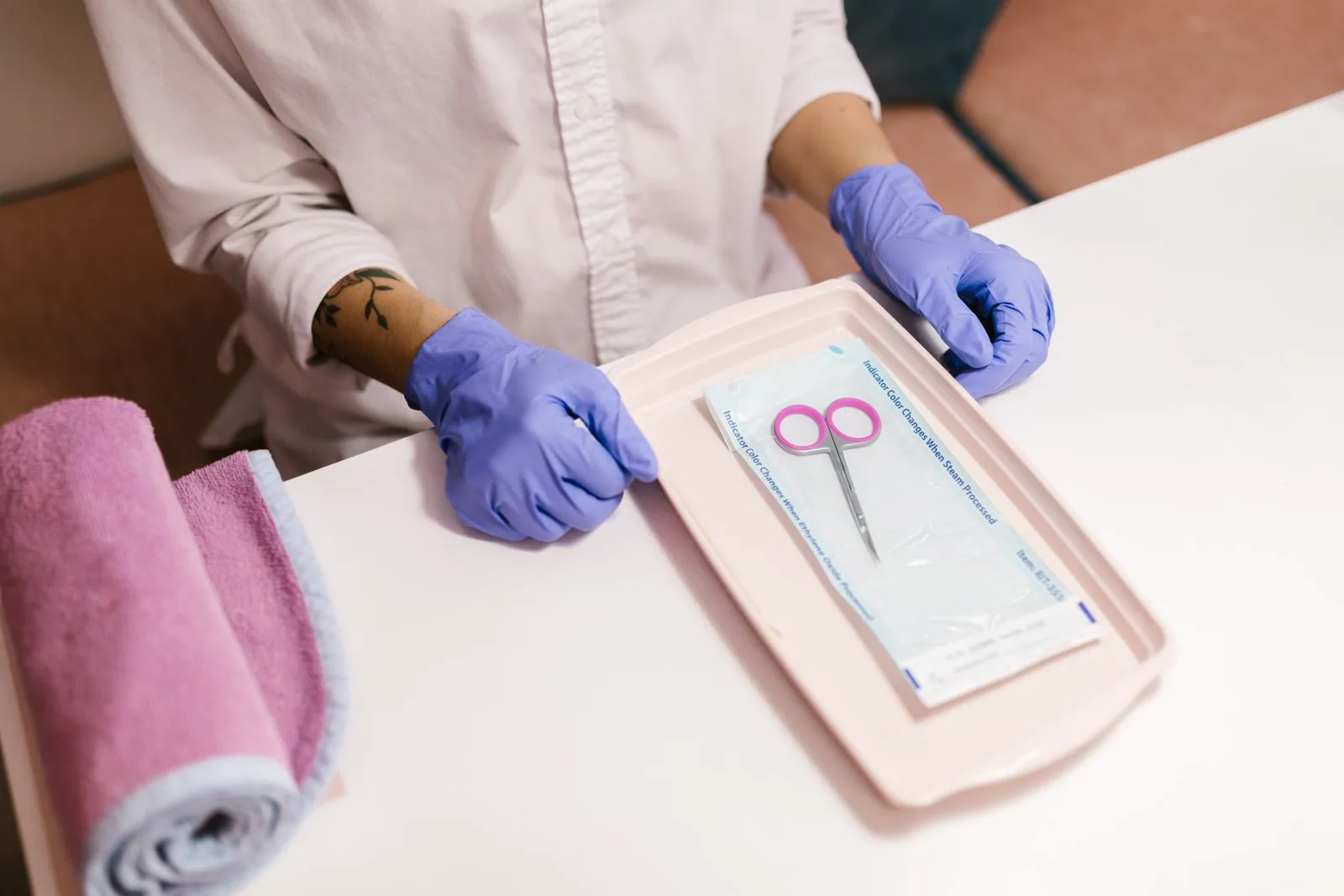 Instrumente de manichiură scoase dintr-o pungă sigilată de sterilizare, cu mănuși
